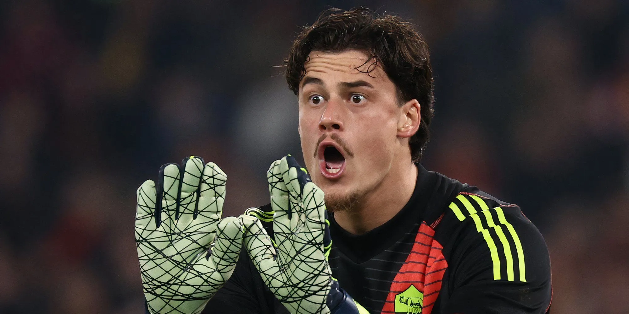 Thủ môn Mile Svilar của Roma trong trang phục đỏ vàng đang đấu tranh giữ bóng